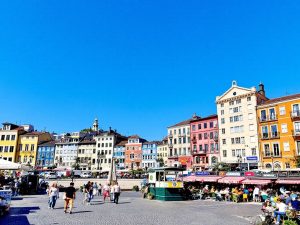 Oraș vibrant cu clădiri colorate și străzi aglomerate.